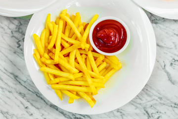 side dishes for the main course,potato fries with ketchup on a white plate, beautiful serve