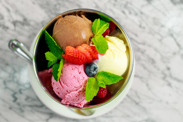 three balls of ice cream with berries and mint, a beautiful serving