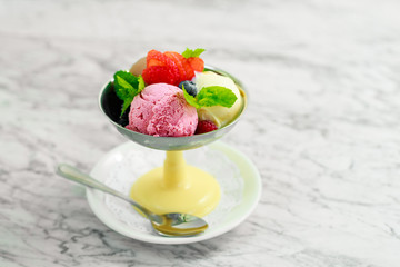 three balls of ice cream with berries and mint, a beautiful serving