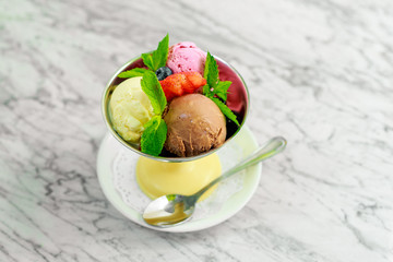 three balls of ice cream with berries and mint, a beautiful serving
