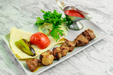 barbecue with grilled vegetables, onions and sauce