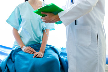 close up Asian male Doctor   explaining diagnosis to his female patient.   Doctor discussing test results with patient. ,in the hospital/ corona virus and Covid-19 concept.