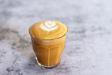 hot latte coffee in glass on white table background.