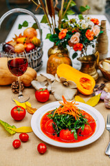Autumn table setting with pumpkins. Thanksgiving dinner. pickled tomatoes with arugula and carrots. Vegetarian healthy food.