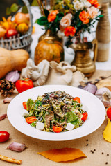 Autumn table setting with pumpkins. Thanksgiving dinner. vegetarian salad with tomatoes and cheese. Healthy food
