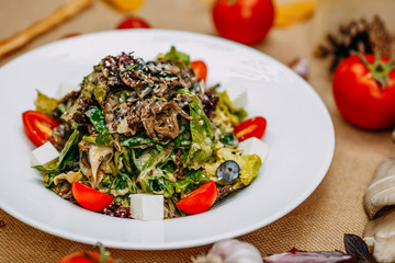 Autumn table setting with pumpkins. Thanksgiving dinner. vegetarian salad with tomatoes and cheese. Healthy food