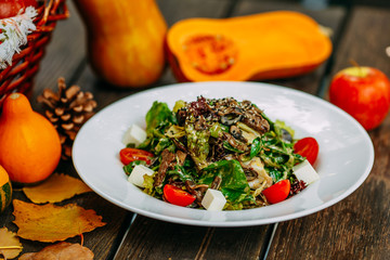 Autumn table setting with pumpkins. Thanksgiving dinner. vegetarian salad with tomatoes and cheese. Healthy food