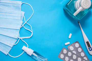 Concept of Coronavirus or Covid-19 pandemic protection to use as background with blue colour and mask, thermometer, pill, vitamins hand soap, sanitiser, medicines, thermometer