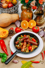 Autumn table setting with pumpkins. Thanksgiving dinner. sausages with fried potatoes in a pan