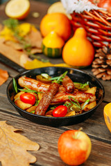 Autumn table setting with pumpkins. Thanksgiving dinner. sausages with fried potatoes in a pan