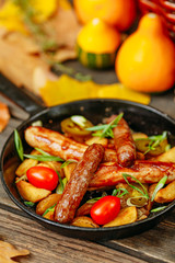Autumn table setting with pumpkins. Thanksgiving dinner. sausages with fried potatoes in a pan