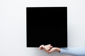 Hands hold a black sheet. Empty space for the label.