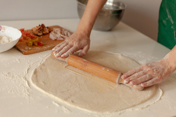 Preparation of the dough for pizza. Hands prepare the dough