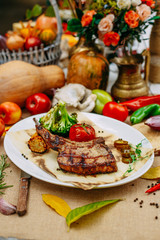 Autumn table setting with pumpkins. Thanksgiving dinner.Tomahawk Pork Steak with Vegetables