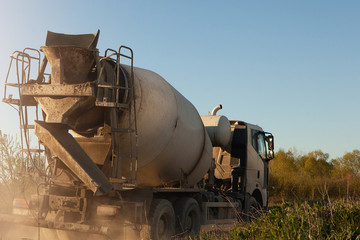Fototapeta na wymiar Construction equipment. A concrete mixer is driving along a country road. 