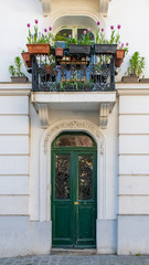 Paris, an old wooden door, with tulips on the balcony, typical building in Montmartre
