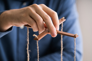 Person Manipulating Marionette With String