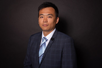 Chinese man in suit looking seriously, confidently at camera. Business portrait