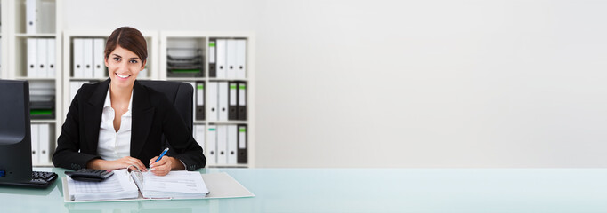 Female Accountant Writing On Documents