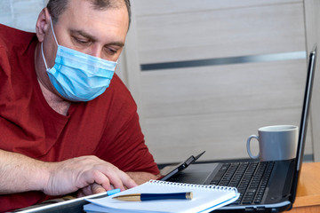 quarantine due coronavirus pandemic. stay at home. business man working from home, wear a protective mask. Work from home with disinfectant gel. remote work, learning due to the epidemic COVID-19.