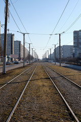 Fototapeta premium Tram tracks with poles in the city. In the distance are trams.