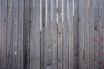 Old scratched wooden fence with gaps. Texture.