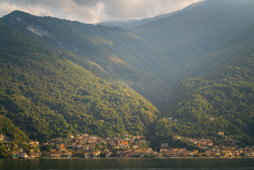 Fototapeta na wymiar A scenic view of beautiful Lake Como from an old villa with a small town and mountains in the background in Northern Italy