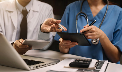 Doctors working together on digital tablet healthcare doctor technology tablet using computer in a modern office.