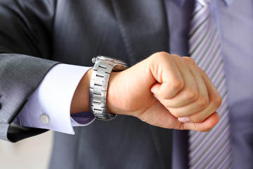 Man in suit and tie check out time at silver wristwatch closeup. Waste minute, modern punctual life style, start hurry, job idea, last second, clockwork precision concept