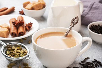 Indian drink masala tea with milk and spices. Cardamom sticks cinnamon star anise cane sugar.