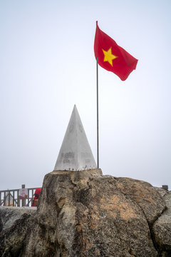 Vietnamese flags and monument at summit of Fansipan - the highest mountain in Indochina located in Sapa Hoang Lien Son mountain range, Lao Cai Province, Vietnam
