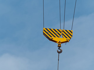 Industry. Metal hook with lifting cable mechanism with blue sky background. Close-up.