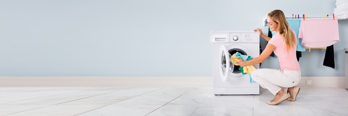 Woman Putting Clothes In Washing Machine