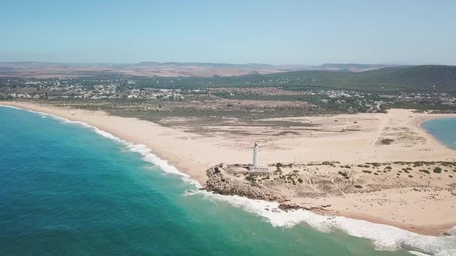 Aerial view of Cape Trafalgar lighthouse,  Cadiz, south-west of Spain. Atlantic Ocean, northwest of the Strait of Gibraltar. In 1805 naval Battle of Trafalgar took place here. Front Dolly tilt Down