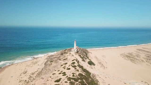 Aerial view of Cape Trafalgar lighthouse,  Cadiz, south-west of Spain. Atlantic Ocean, northwest of the Strait of Gibraltar. In 1805 naval Battle of Trafalgar took place here. Back dolly video