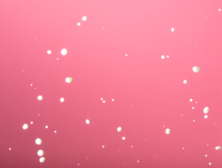 Splashing milk on a pink background.