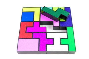 Obraz premium Multi-colored puzzle made of plastic blocks, that's missing one piece, isolated on white background