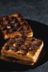 Fototapeta na wymiar waffles with chocolate on a black plate dessert