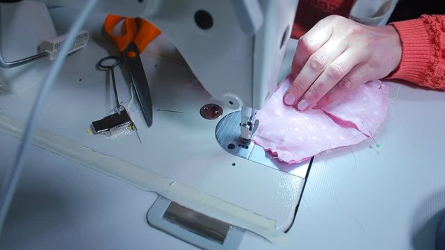 Video tutorial on making a mask on a face from fabric. Sewing an element of clothing on a sewing machine. Hobbies in his free time.