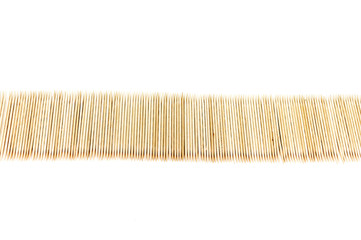 Large number of toothpicks lined up in a long row, isolated on white background
