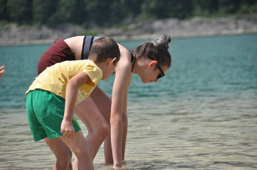 Children, siblings playing in the water. Black lake in the Durmitor mountains near Zabljak. A beautiful place in Montenegro