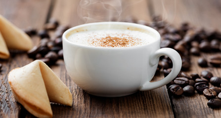 Cup of cappuccino coffee with cinnamon  on wooden table.