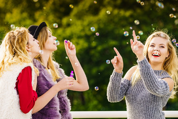Women blowing soap bubbles, having fun