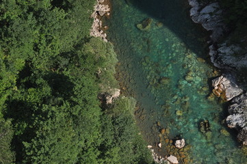 The bridge on the Tara River in Montenegro and the bridge connecting the two banks of the canyon. A stony bed of a clean river flowing through the valley along the road on a mountain slope.