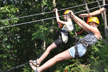 Mother and daughter riding down a zipline over the Tara Gorge, a river in Montenegro with the...