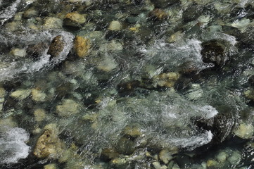 The bridge on the Tara River in Montenegro and the bridge connecting the two banks of the canyon. A stony bed of a clean river flowing through the valley along the road on a mountain slope.