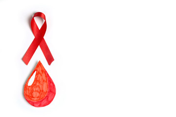 Dop of blood symbol with red ribbon on a white background with copy space.