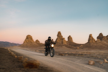 Biker riding motorcycle on dirt road in Monument Valley