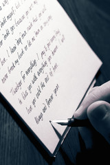 Man writing a love letter with a fountain pen.  With colour toning