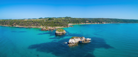 Aerial panorama of scenic ocean coastline with rocks and shallow turquoise water near Walkerville...